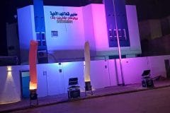 واجهة مبنى مضاءة بإضاءة بنفسجية وزرقاء مع بالونات هوائية مضيئة